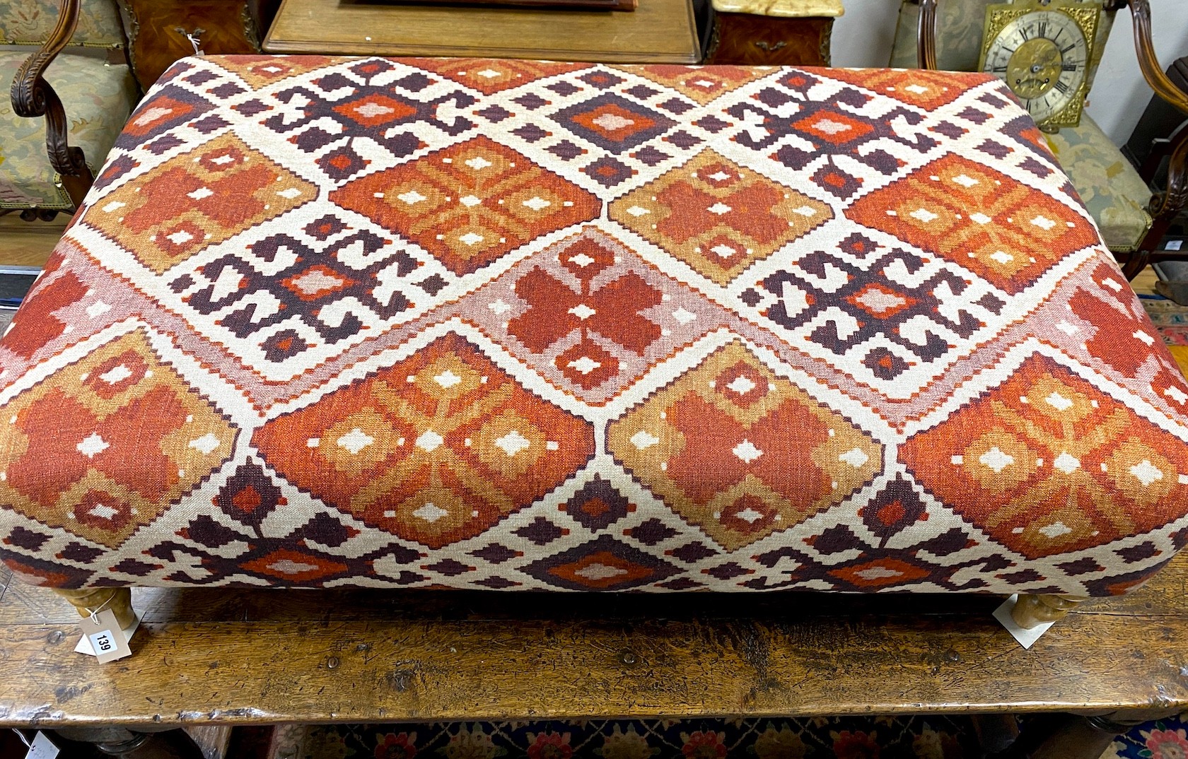 A large contemporary rectangular footstool upholstered in Kilim style fabric on turned beech feet, length 125cm, depth 74cm, height 39cm